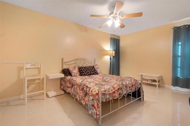 tiled bedroom featuring ceiling fan and a textured ceiling