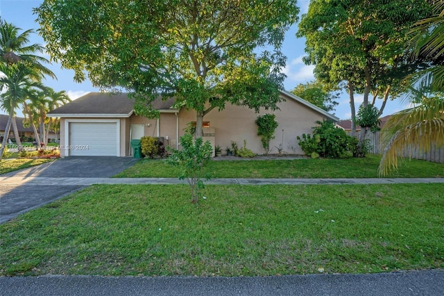 single story home with a garage and a front lawn