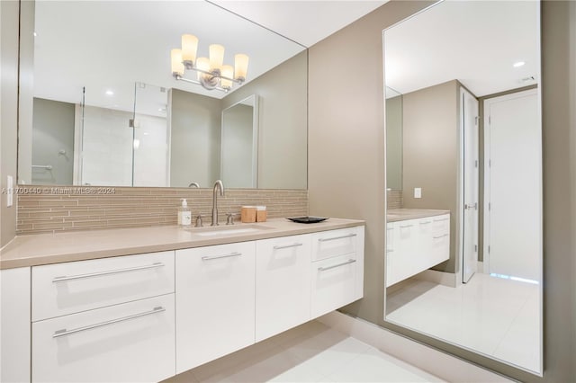 bathroom featuring vanity, a shower with door, tile patterned flooring, tasteful backsplash, and a notable chandelier