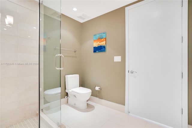 bathroom featuring tile patterned flooring, toilet, and an enclosed shower