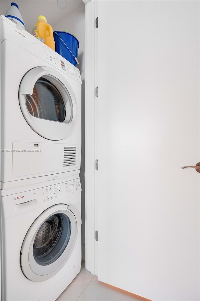 washroom featuring light tile patterned floors and stacked washer / dryer