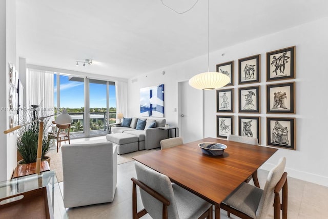 dining room featuring a wall of windows and light tile patterned floors