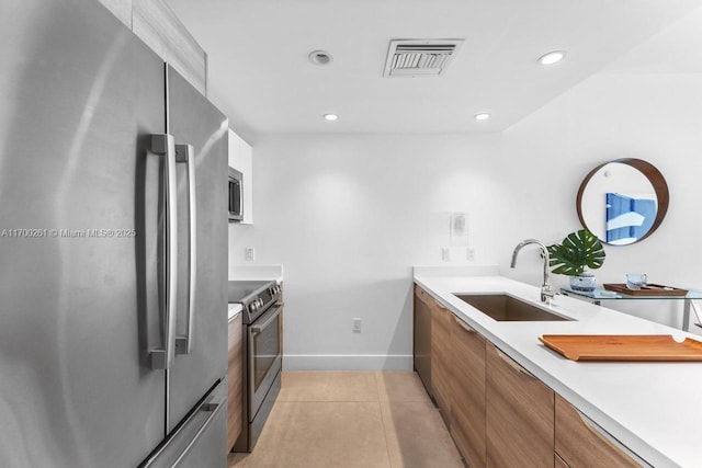 kitchen featuring appliances with stainless steel finishes, light tile patterned floors, and sink