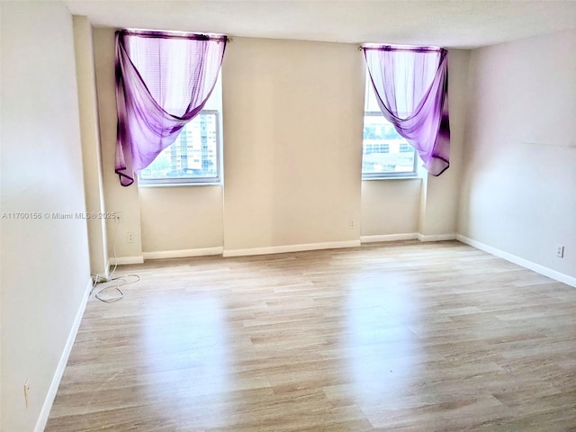 unfurnished room with wood finished floors and baseboards