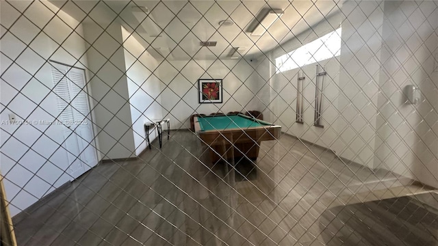 rec room with tile walls, pool table, and dark tile patterned floors