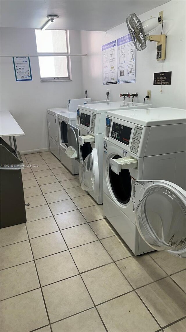 clothes washing area featuring light tile patterned flooring and washing machine and clothes dryer