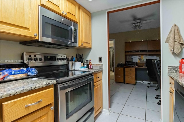 kitchen featuring light tile patterned floors, stainless steel appliances, light stone counters, and ceiling fan