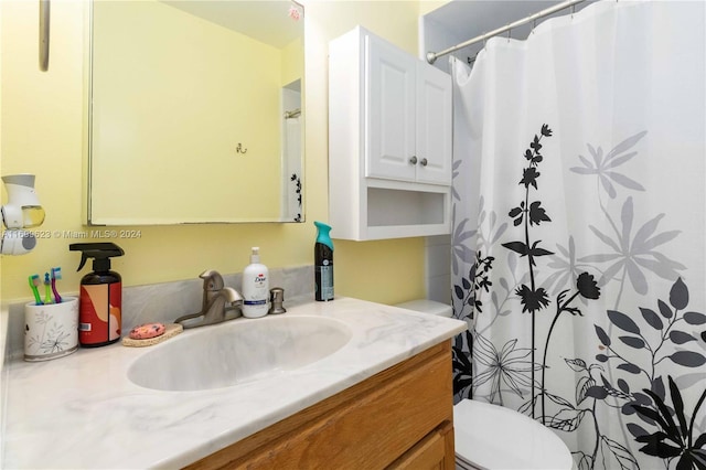 bathroom with walk in shower, vanity, and toilet