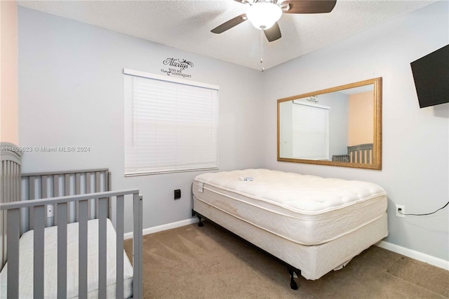 carpeted bedroom with a textured ceiling and ceiling fan