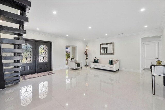 foyer entrance with light tile patterned floors, crown molding, and french doors