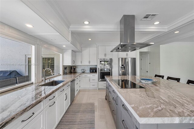 kitchen with island exhaust hood, sink, beamed ceiling, white cabinets, and light stone counters