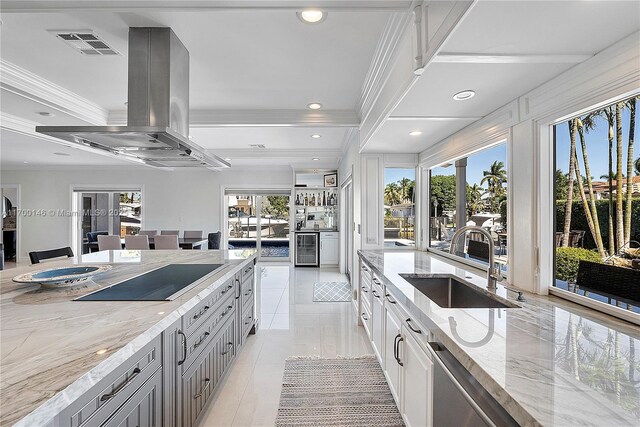 kitchen with a kitchen island, island exhaust hood, gray cabinetry, and black electric stovetop