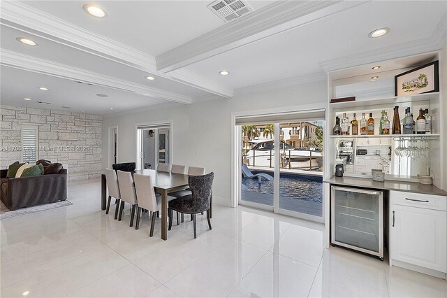 tiled dining space featuring ornamental molding, a healthy amount of sunlight, and wine cooler