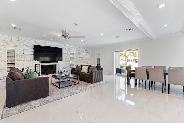 living room with a fireplace, ornamental molding, ceiling fan, light tile patterned floors, and beam ceiling