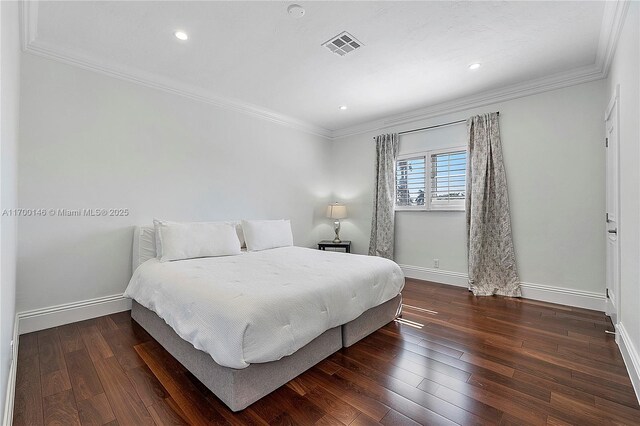 bedroom with dark hardwood / wood-style floors and crown molding