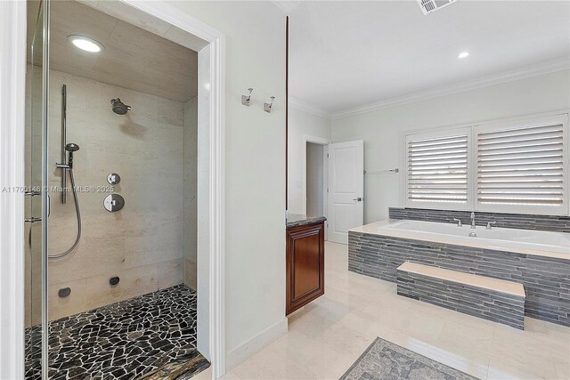 bathroom featuring tile patterned floors, crown molding, a relaxing tiled tub, and vanity