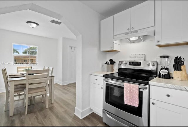 kitchen featuring white cabinetry, stainless steel range with electric stovetop, and light wood-type flooring