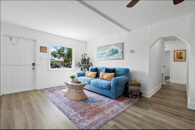 living room featuring beamed ceiling, wood-type flooring, and ceiling fan