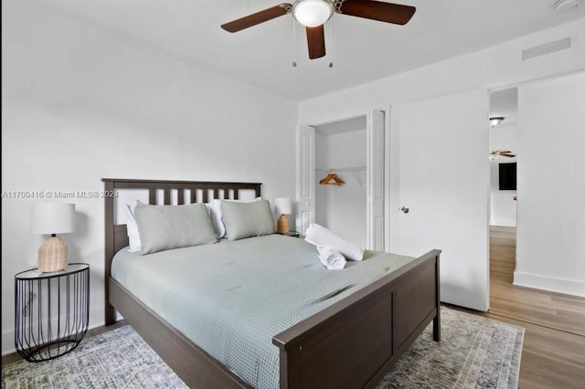 bedroom with hardwood / wood-style flooring, ceiling fan, and a closet