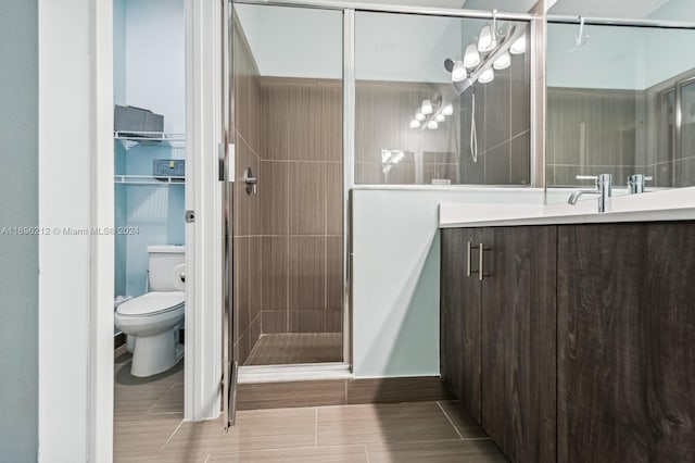 bathroom with vanity, a shower with shower door, and toilet