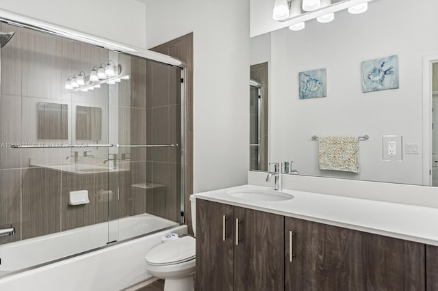 full bathroom featuring vanity, enclosed tub / shower combo, and toilet