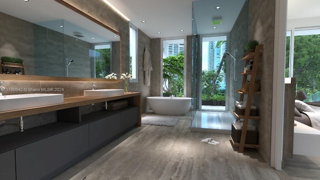 bathroom featuring vanity, hardwood / wood-style flooring, separate shower and tub, and plenty of natural light