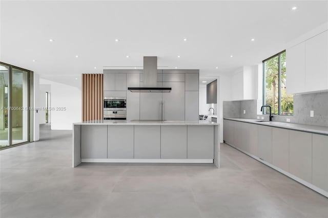 2110 S Miami Ave, Miami, FL 33129 - kitchen with island range hood, modern cabinets, a large island, and backsplash