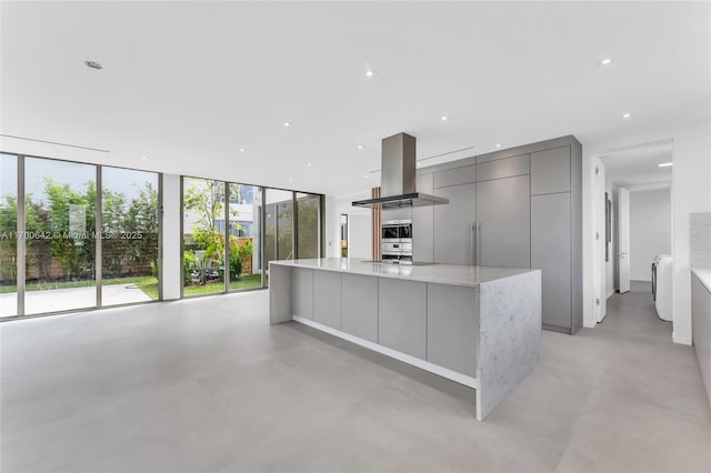 2110 S Miami Ave, Miami, FL 33129 - kitchen with finished concrete floors, island range hood, a spacious island, gray cabinetry, and modern cabinets