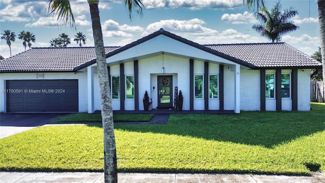 ranch-style home featuring a front lawn and a garage