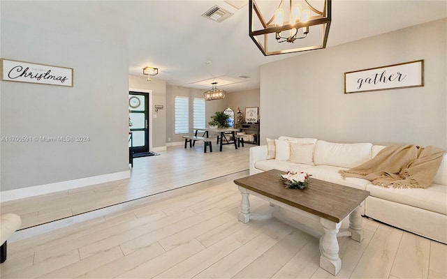 living room featuring a notable chandelier and light hardwood / wood-style floors