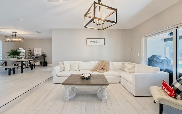 living room with light hardwood / wood-style flooring and a notable chandelier