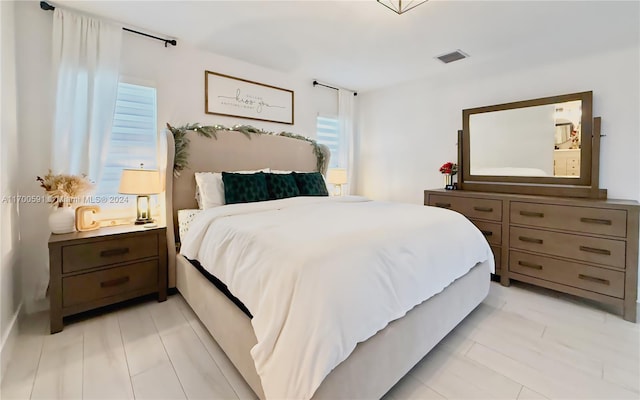 bedroom featuring multiple windows and light hardwood / wood-style flooring