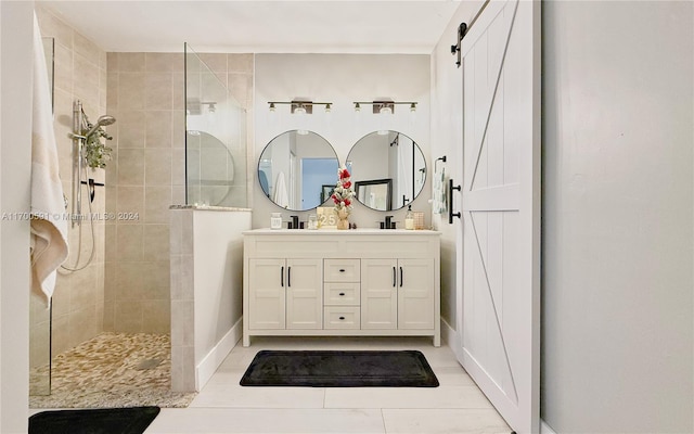 bathroom featuring tiled shower, vanity, and tile patterned floors