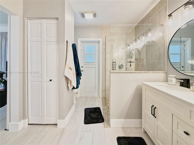 bathroom with vanity and tiled shower