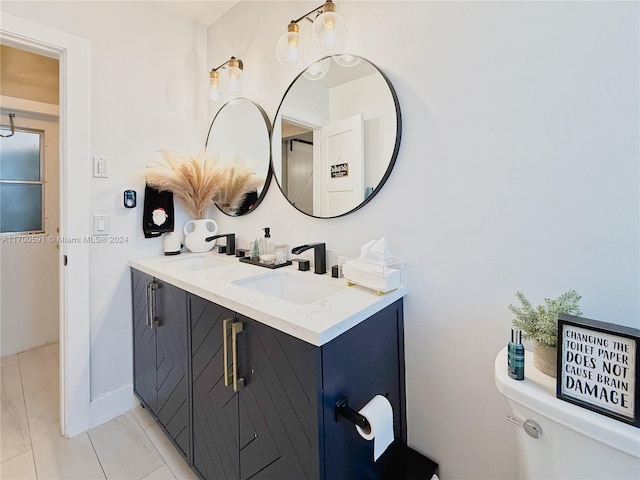 bathroom with tile patterned flooring, vanity, and toilet