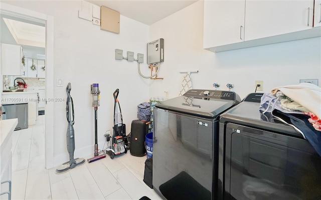 clothes washing area featuring sink, cabinets, and independent washer and dryer