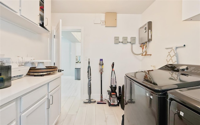 clothes washing area featuring washing machine and clothes dryer and cabinets