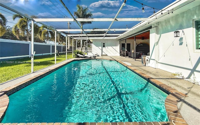 view of swimming pool with a lawn, a lanai, and a patio