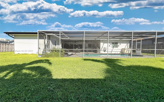 rear view of house with a lanai and a lawn