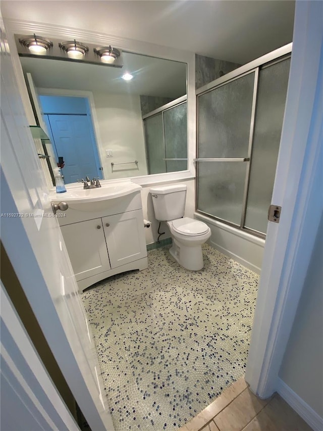 full bathroom featuring tile patterned floors, vanity, toilet, and enclosed tub / shower combo