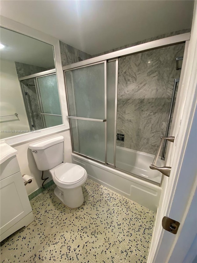 full bathroom featuring vanity, enclosed tub / shower combo, and toilet