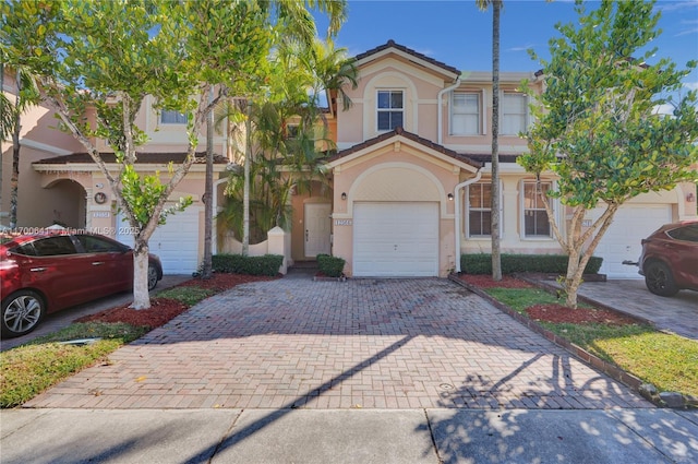 12564 SW 121st Way, Miami, FL 33186 - townhome / multi-family property with stucco siding, decorative driveway, and an attached garage