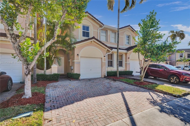 12564 SW 121st Way, Miami, FL 33186 - view of property featuring stucco siding, decorative driveway, and an attached garage