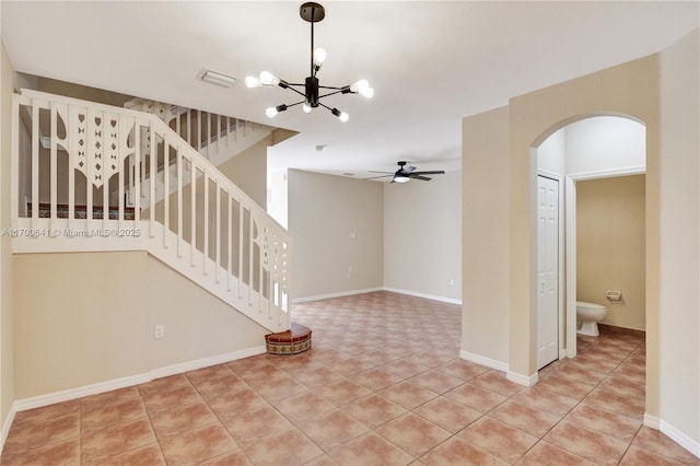 spare room featuring ceiling fan with notable chandelier and light tile patterned floors