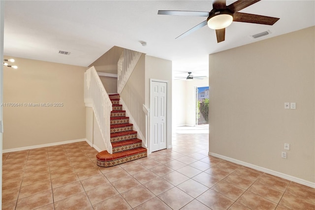 stairway featuring tile patterned flooring and ceiling fan