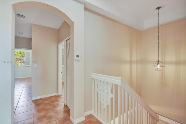 12564 SW 121st Way, Miami, FL 33186 - hall featuring light tile patterned floors, arched walkways, baseboards, and an upstairs landing