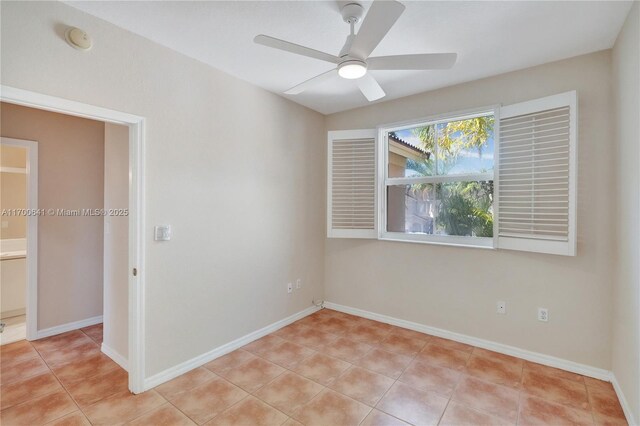 tiled spare room with ceiling fan