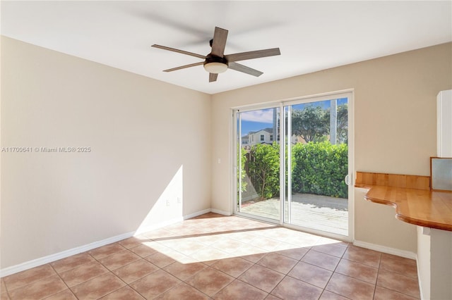 tiled empty room featuring ceiling fan