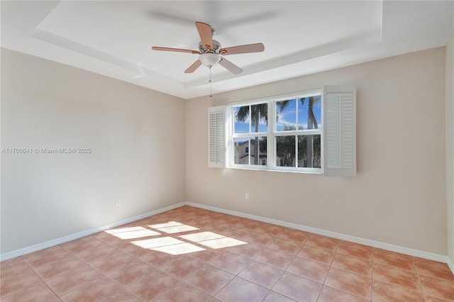 unfurnished room featuring light tile patterned flooring, ceiling fan, and a raised ceiling