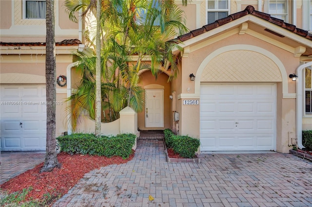 12564 SW 121st Way, Miami, FL 33186 - entrance to property featuring an attached garage, decorative driveway, and stucco siding